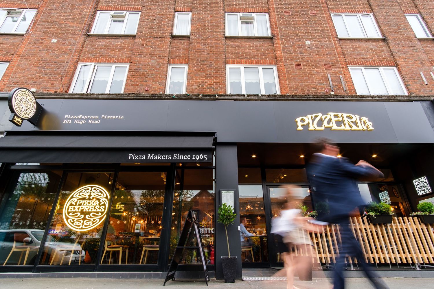 Pizza Express restaurant exterior storefront with brick building and illuminated signage.