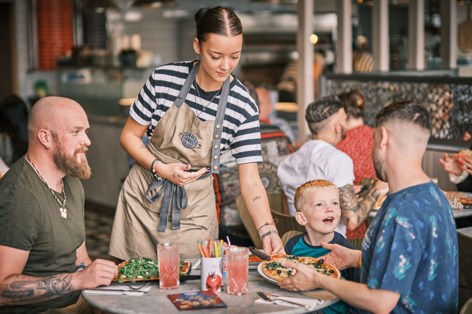 Casual dining scene with customers enjoying meals at restaurant tables.