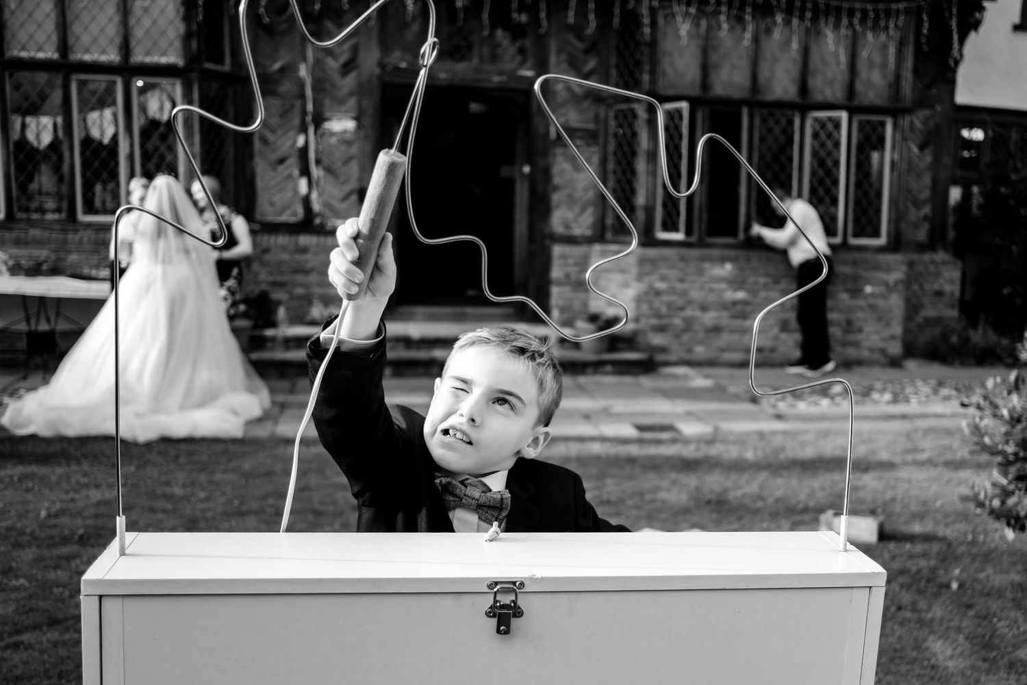 Wedding celebration scene with decorative lighting and outdoor architectural elements in monochrome.