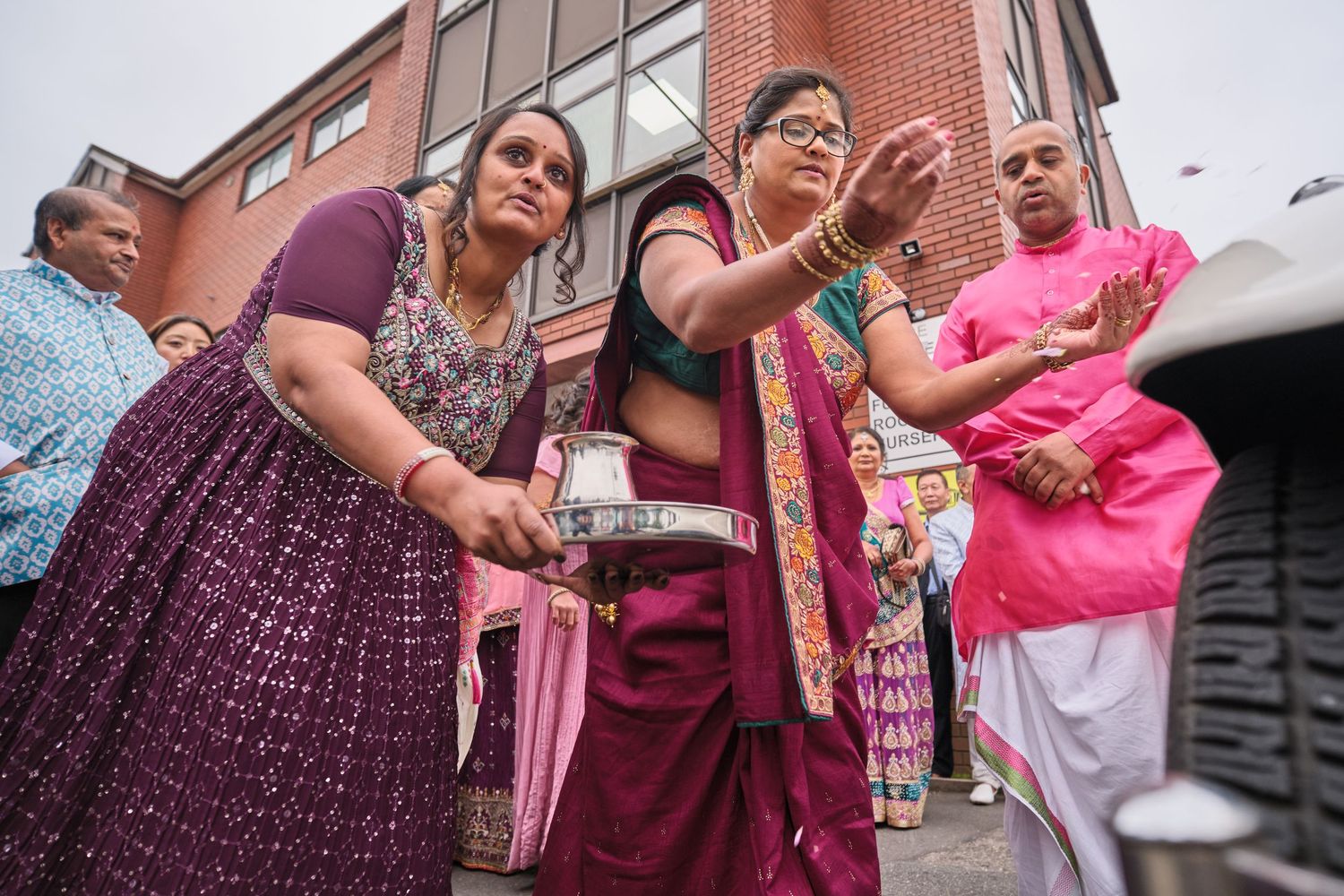 Group of people in traditional Indian attire gathered outside a building.