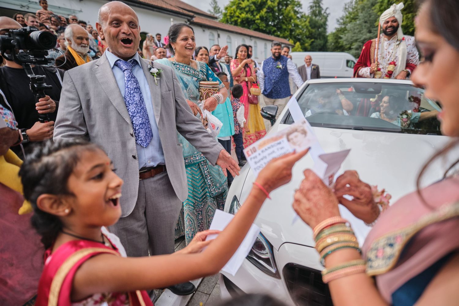 A group gathers outside for a celebratory event with papers and documents being signed and shared.