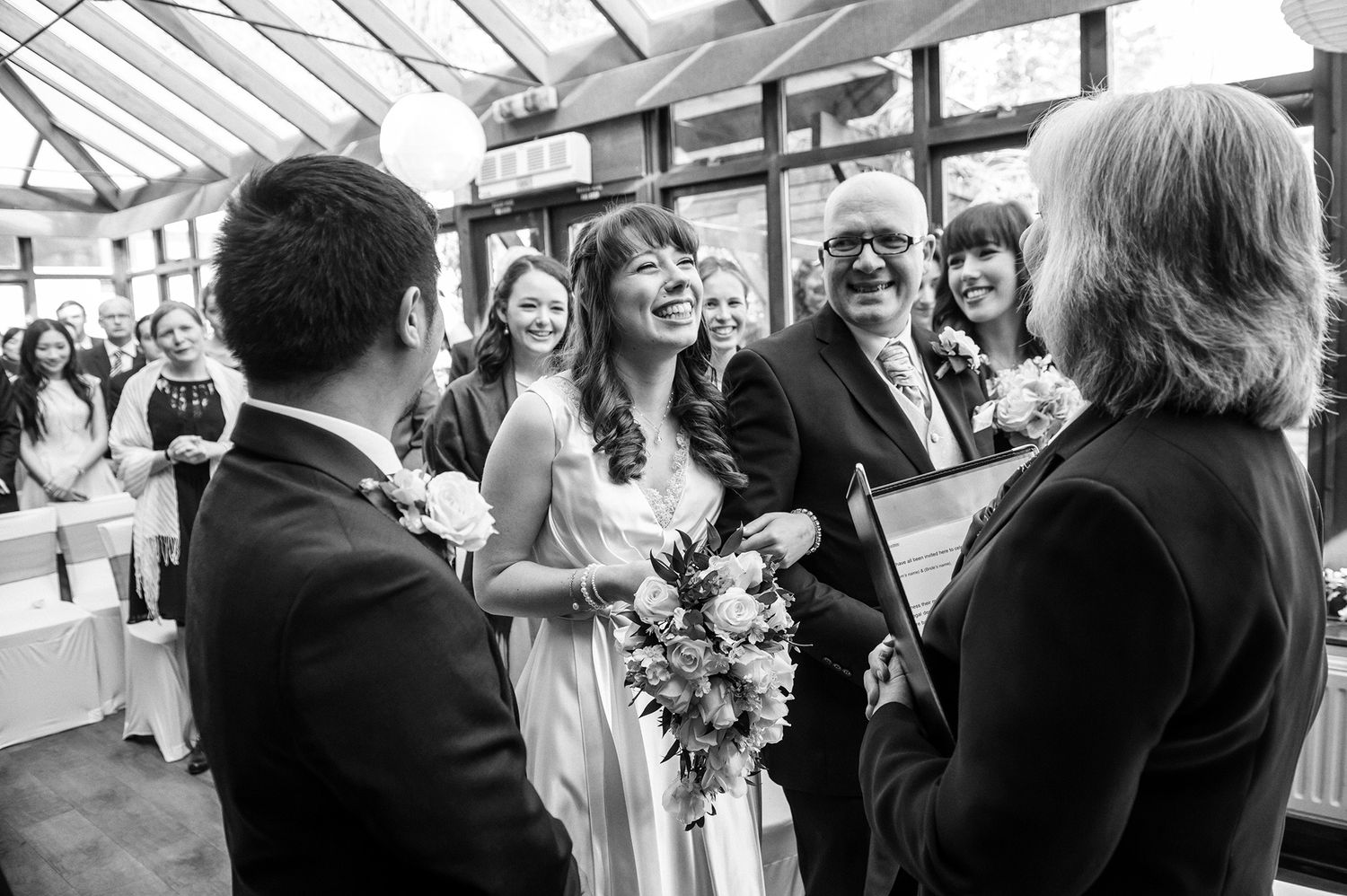 Wedding celebration in a bright conservatory with glass ceiling and natural light.