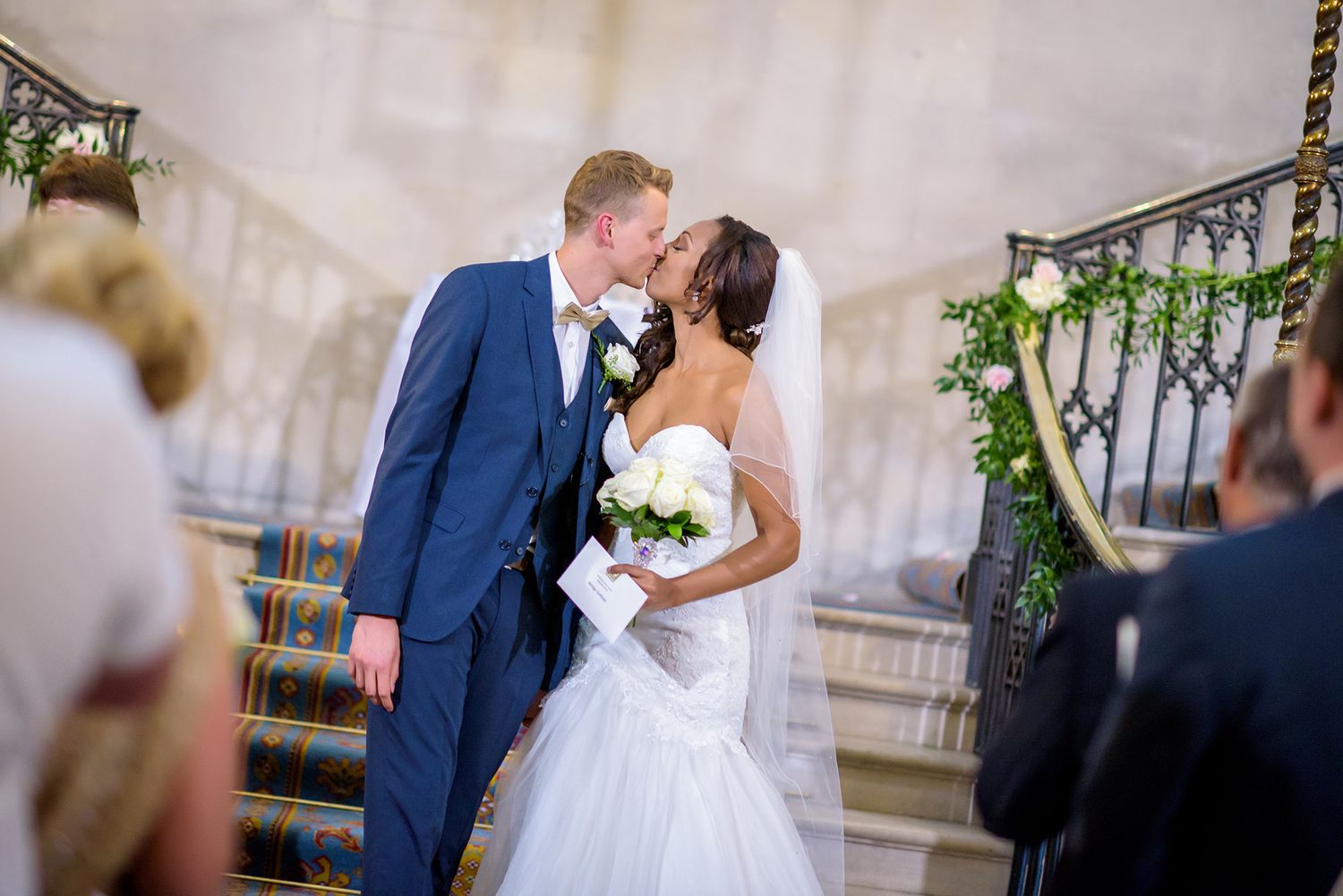 Wedding ceremony exchange of vows on historic mansion staircase.