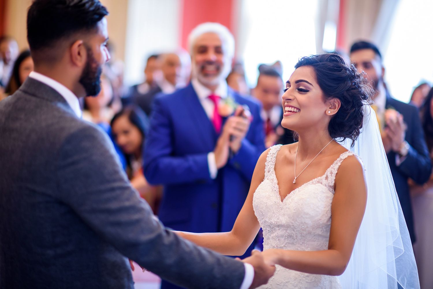 Candid wedding reception scene with dancing and celebration in elegant venue.
