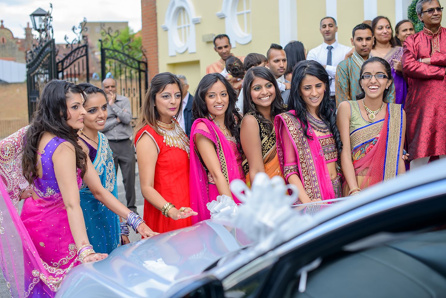 Wedding guests in colorful traditional attire gathered outside the venue.