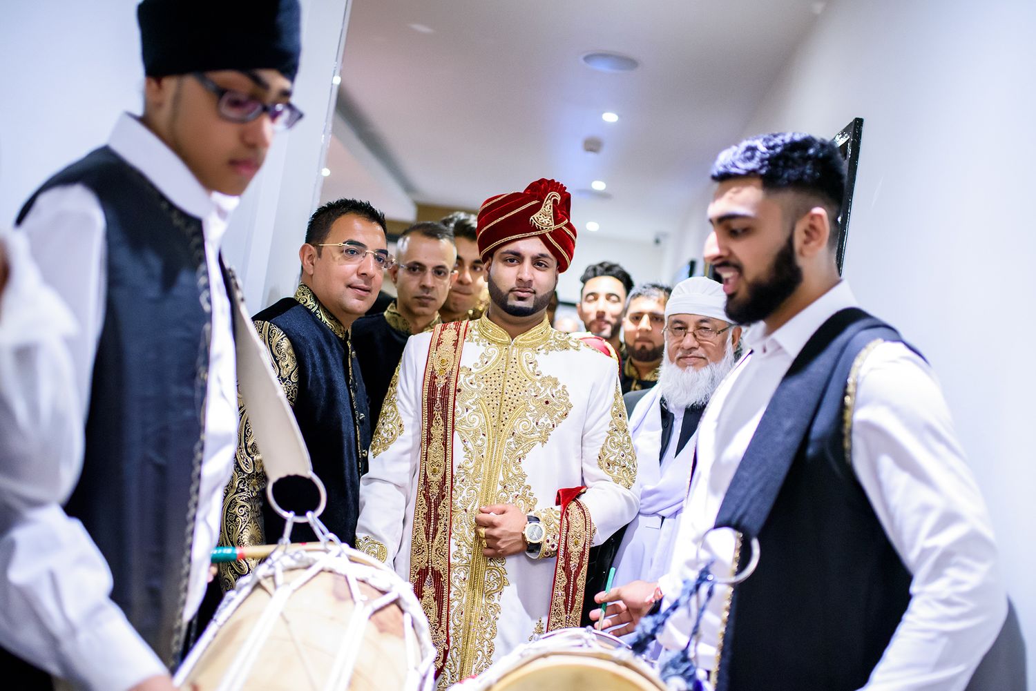 Wedding guests mingling during a reception dressed in formal attire with traditional gold decor.