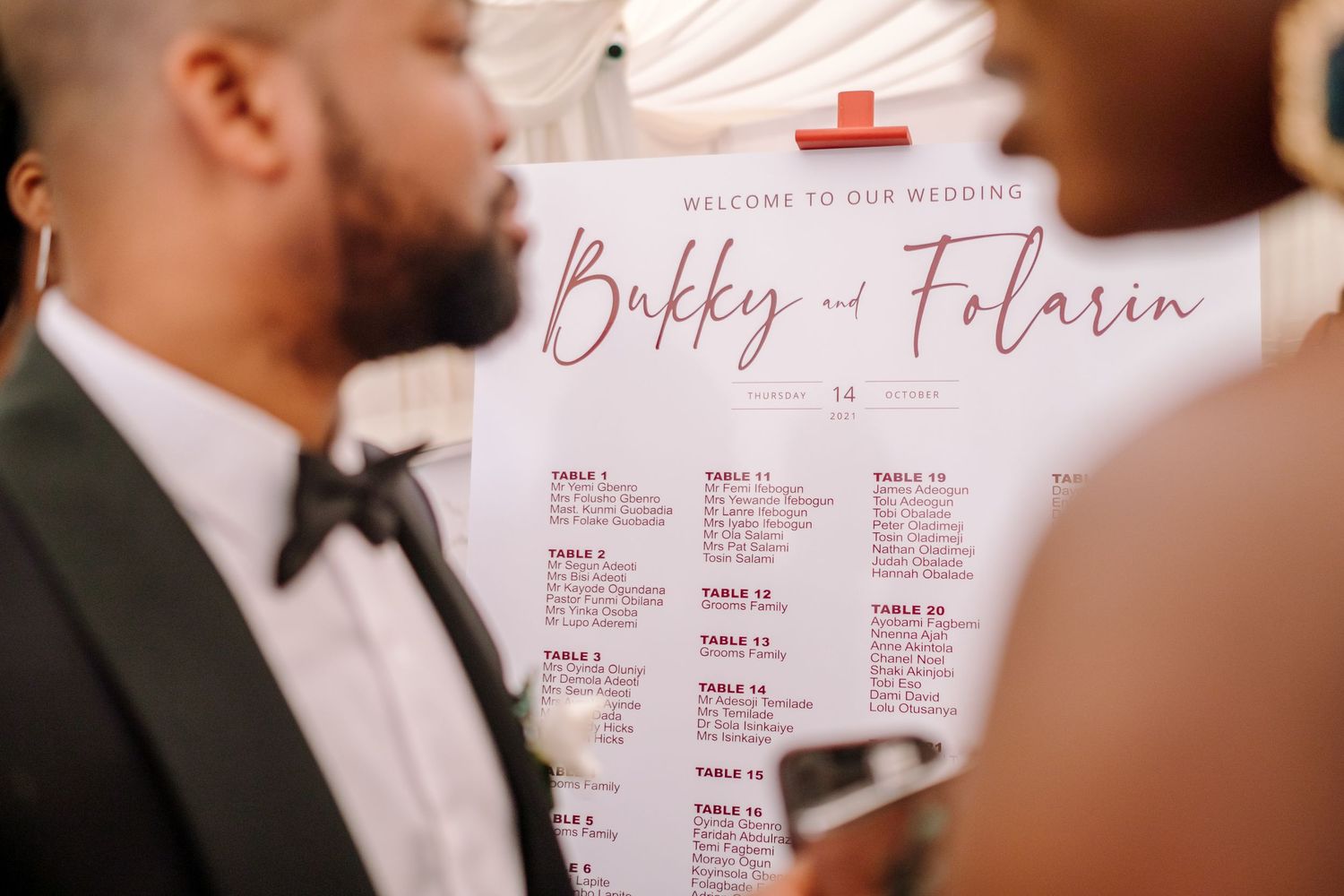 Wedding seating chart display with elegant typography and pink accents.