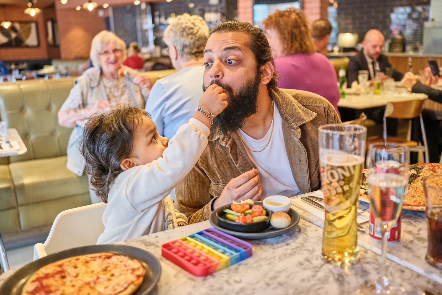 Customers enjoying pizza and drinks at a casual dining restaurant.