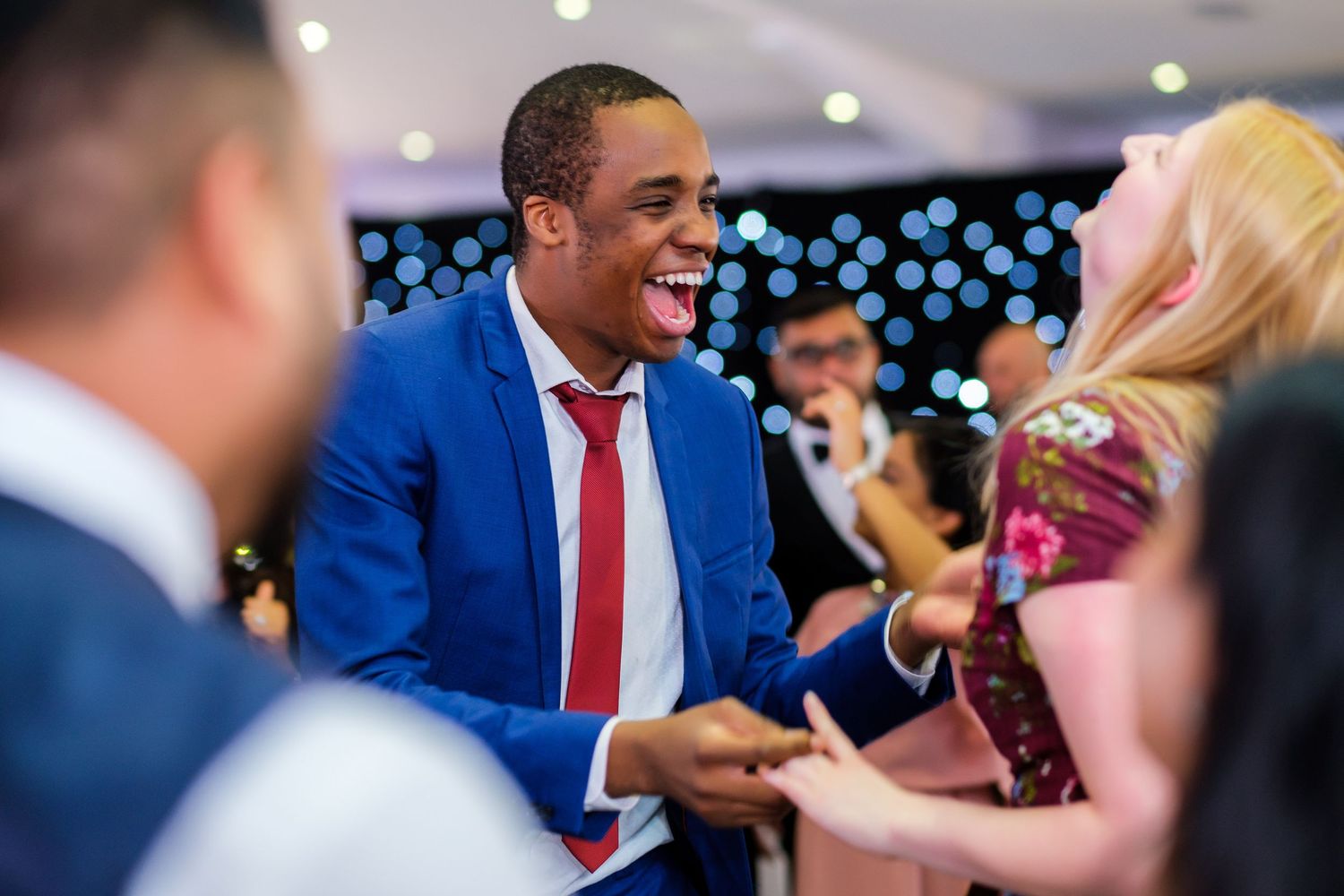 Guests dancing and enjoying themselves at a wedding reception.