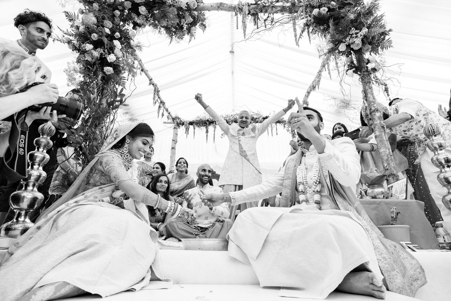 Black and white outdoor wedding photography session under tree branches.