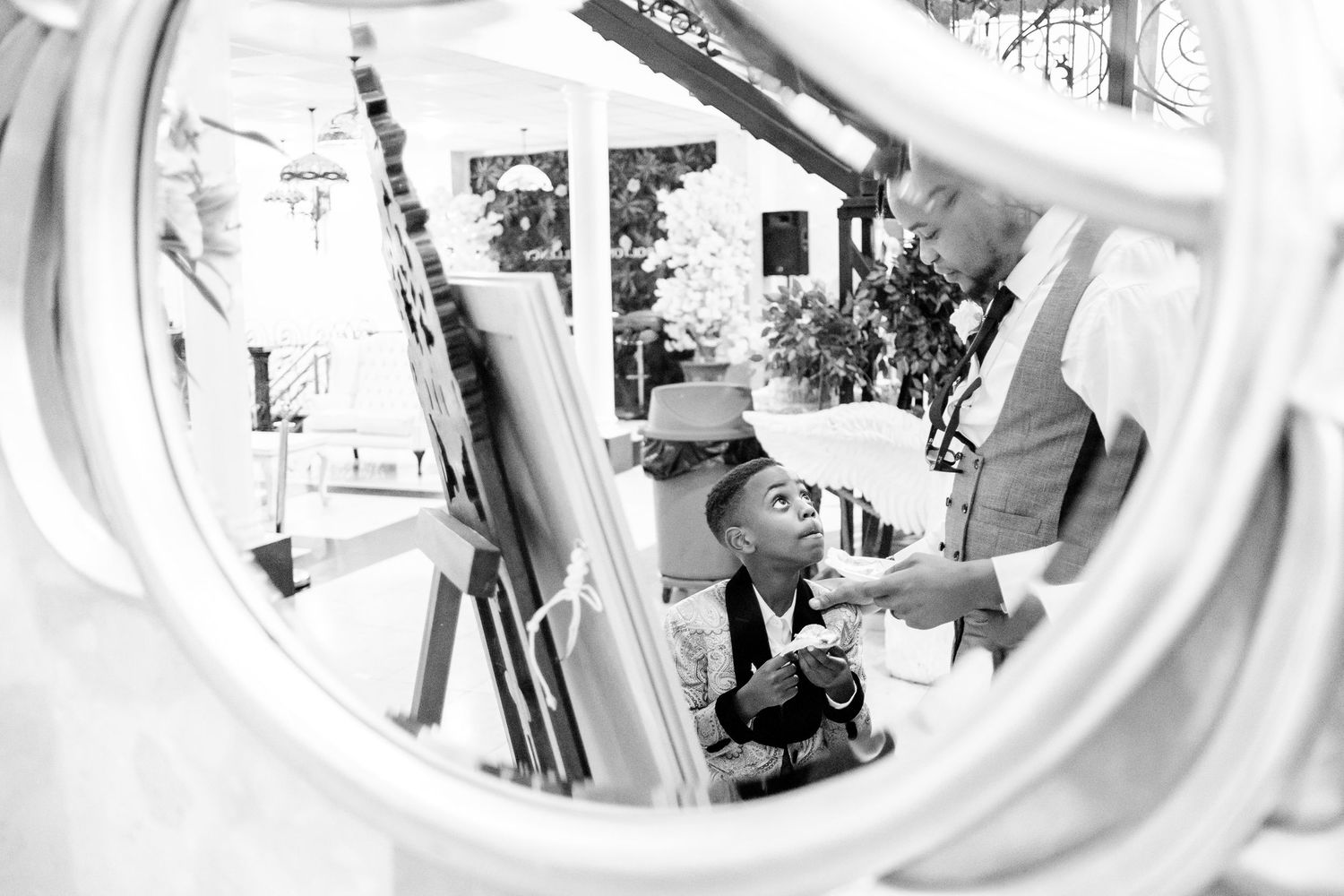 Wedding ceremony captured through decorative circular window frame.