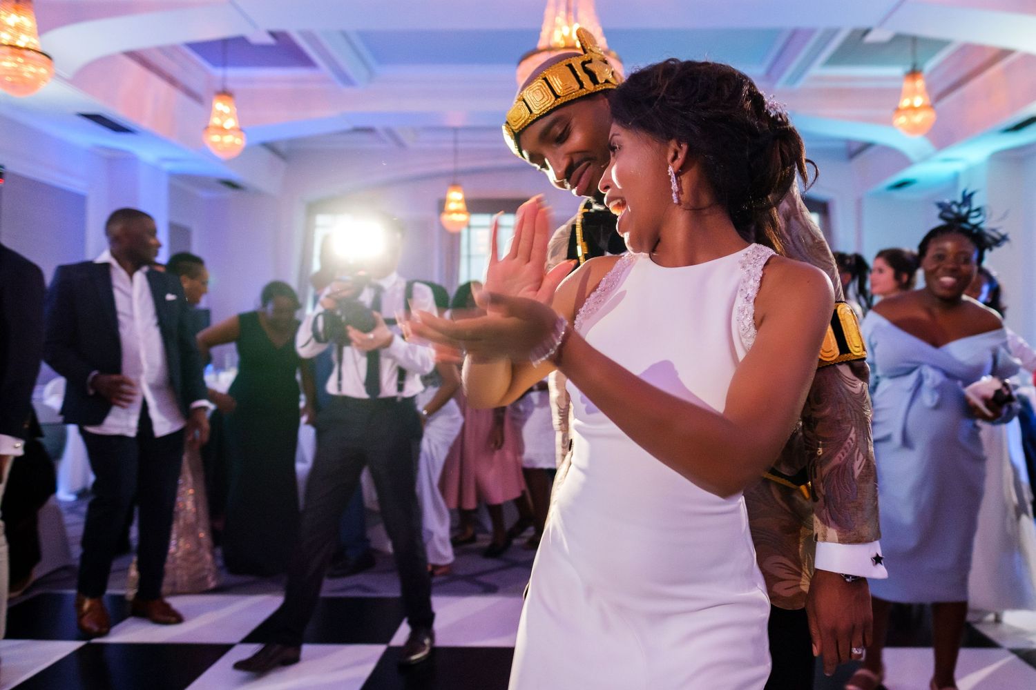 Wedding reception dance floor with blue ambient lighting and guests celebrating.