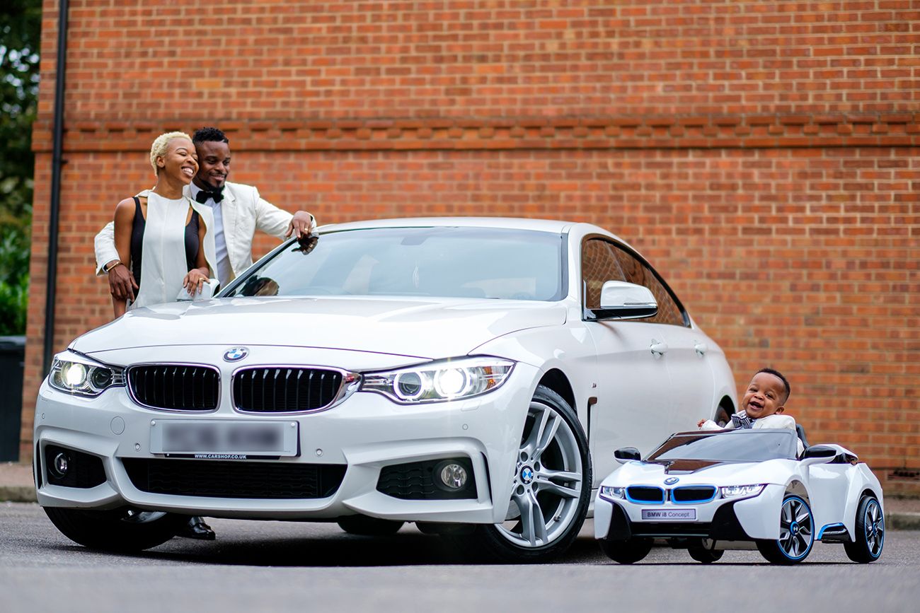 White BMW luxury sedan parked in front of brick building with elegant styling details.