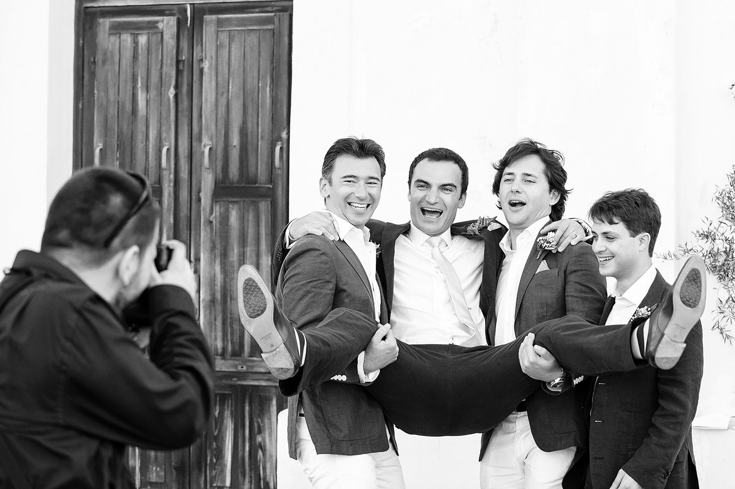 Wedding guests pose playfully in black and white formal attire.