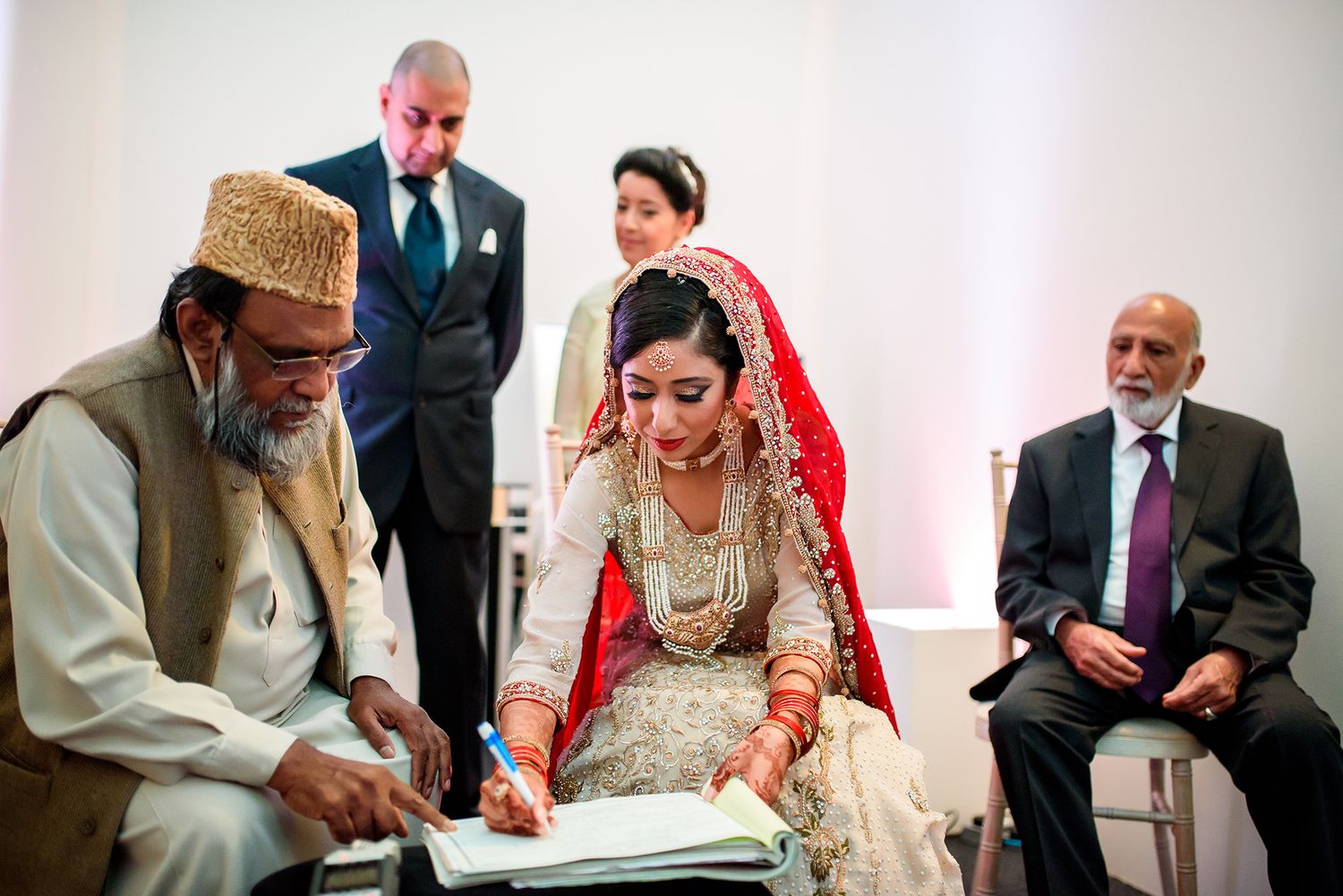 Traditional wedding ceremony with document signing and formal proceedings.
