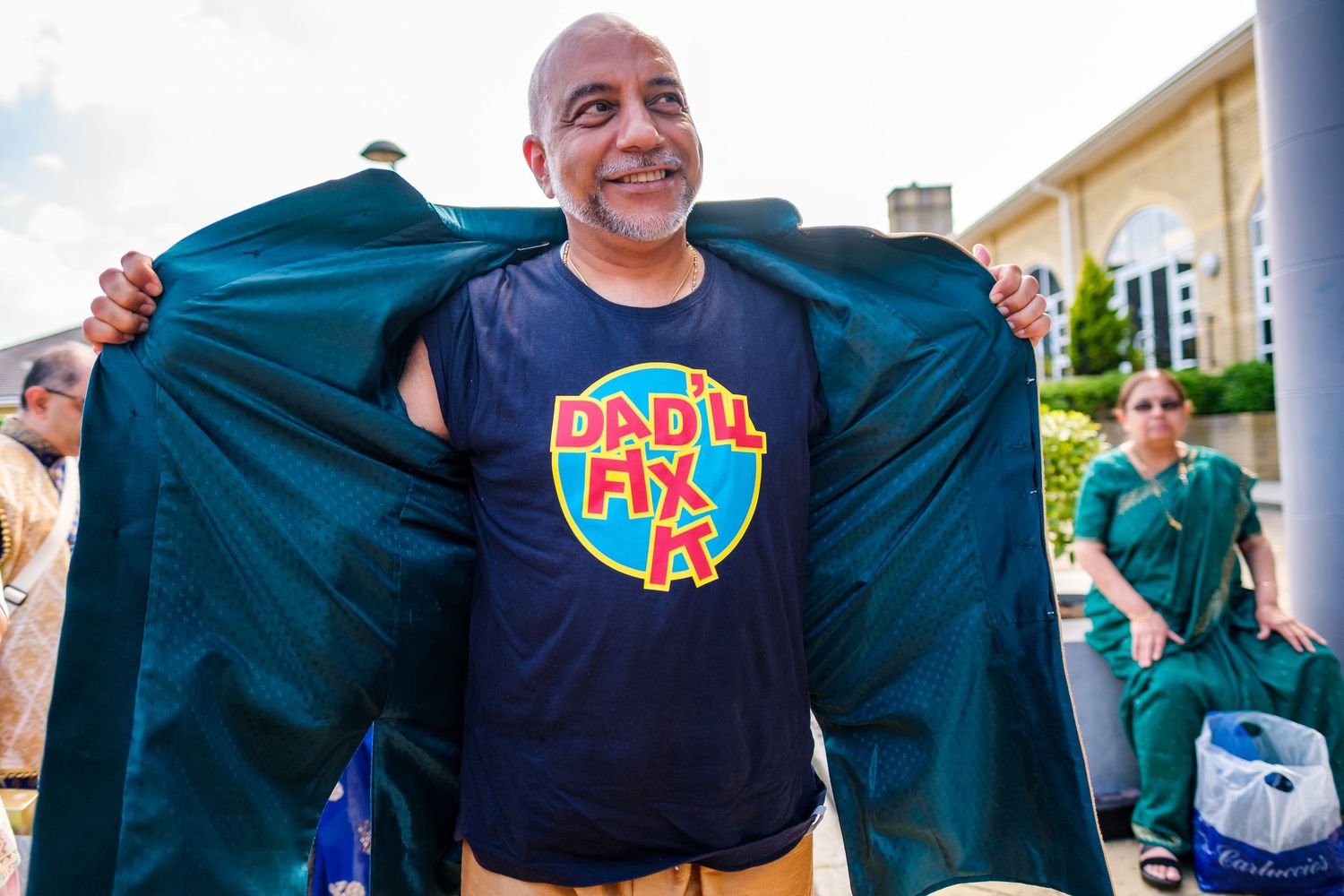 Group of wedding guests displaying matching navy t-shirts with colorful logos.