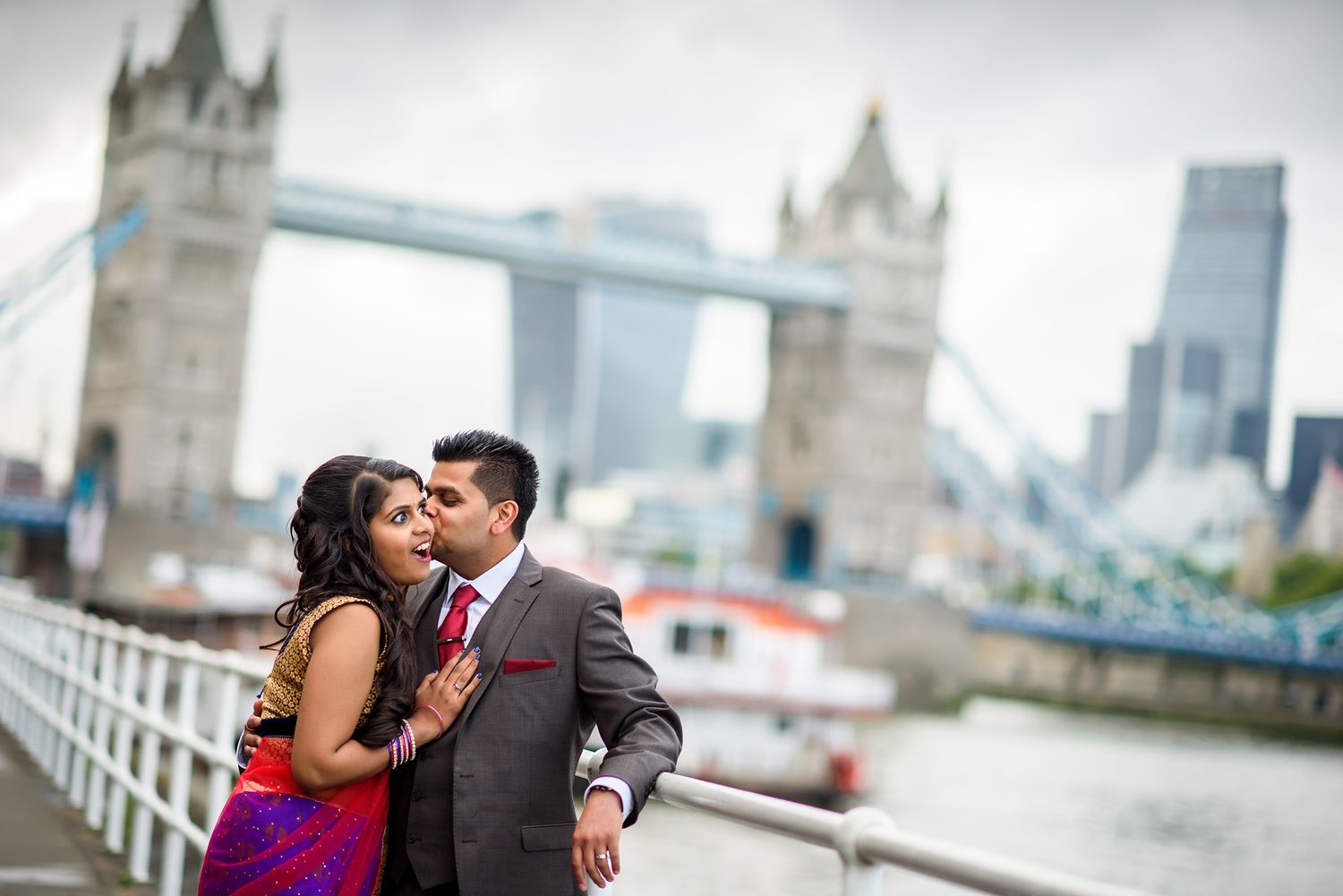 A romantic moment captured on London's Tower Bridge walkway with the Thames River below.