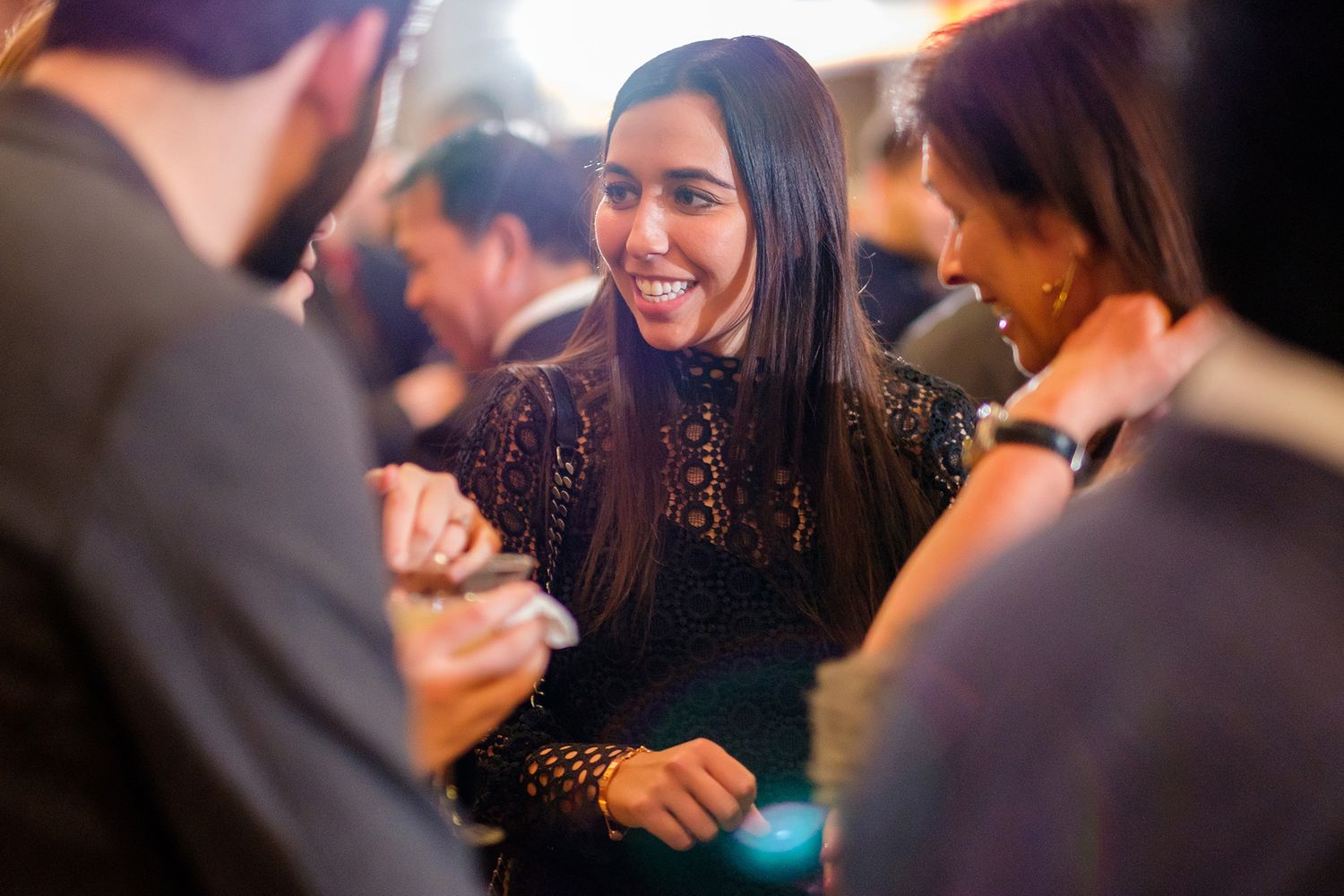 People sharing laughs and conversations at an indoor evening event.