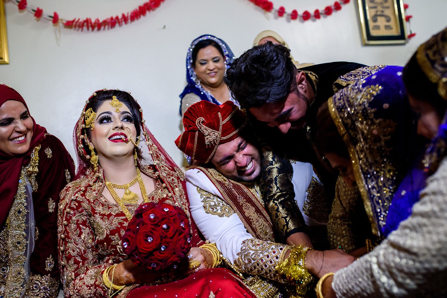 Wedding celebration decorated with red garlands and festive party streamers.