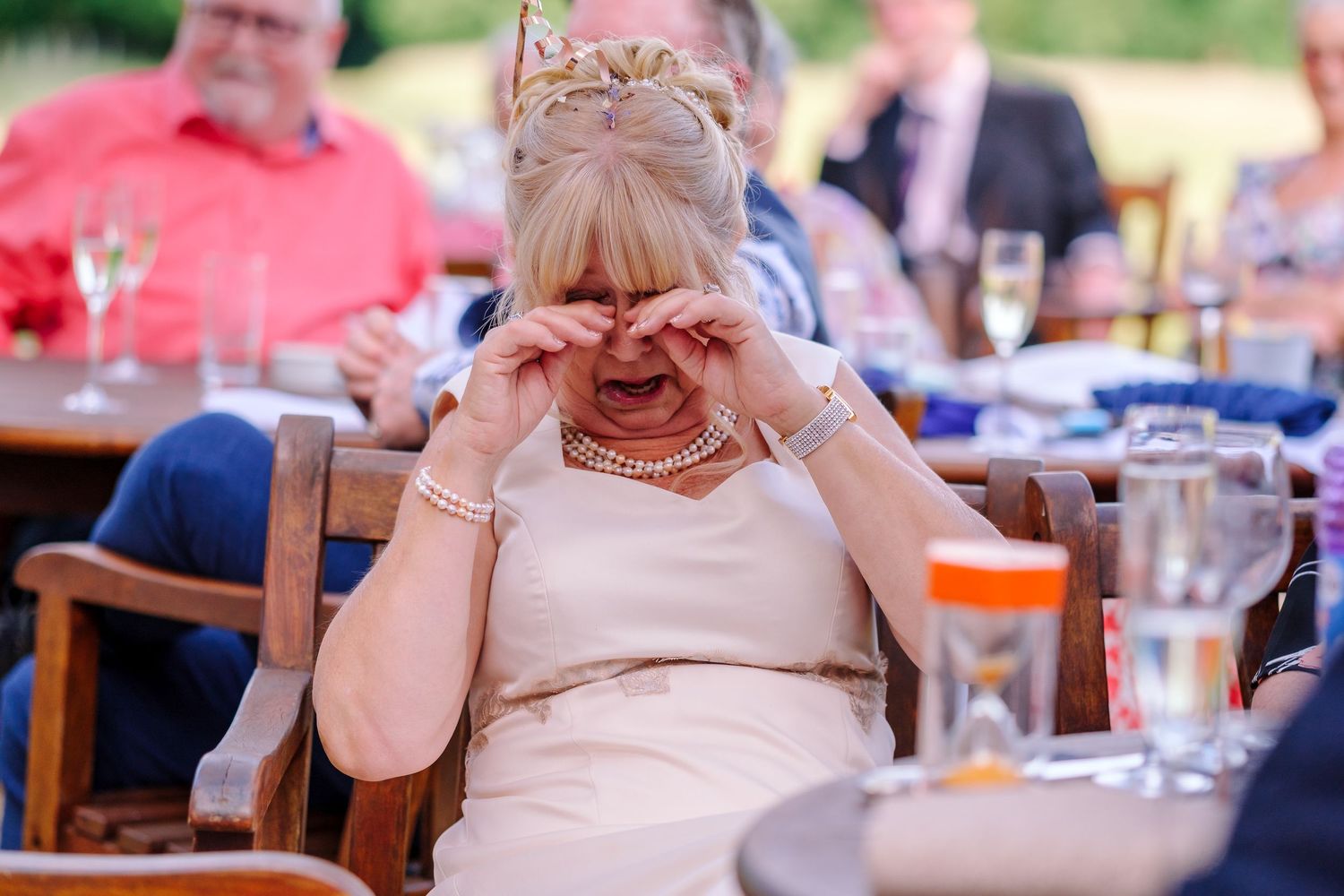 Wedding reception guests enjoying outdoor celebration with table settings and decorations.