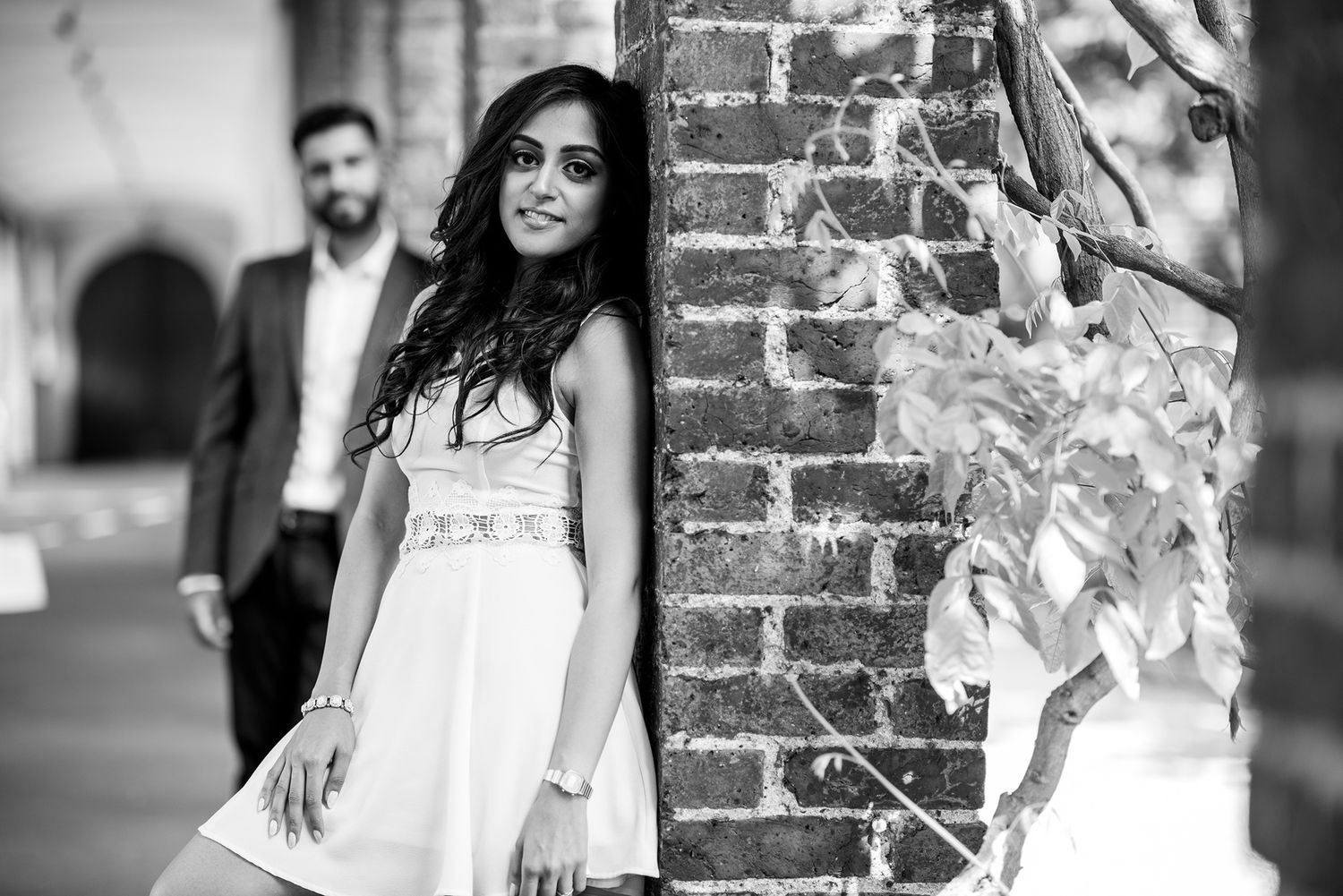 Black and white portraits against rustic brick wall backdrop.