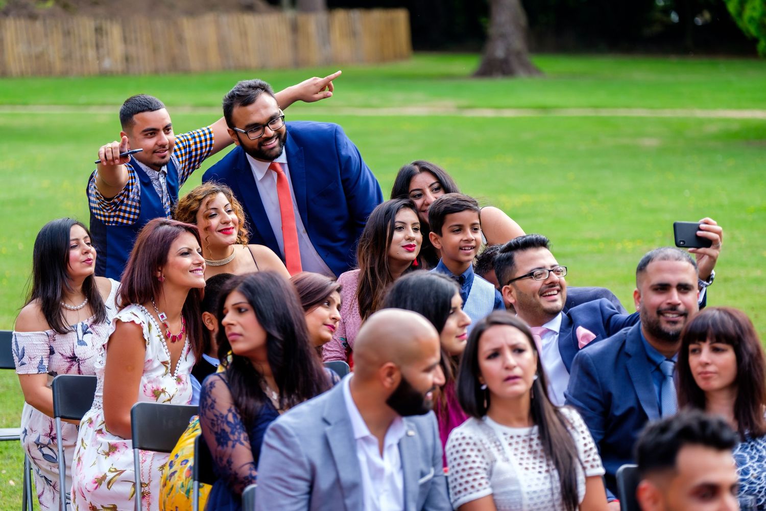 Wedding guests gathered outdoors on a lawn watching the celebration unfold.