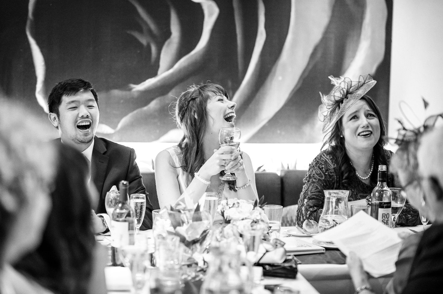 Black and white images capturing laughter and joy during wedding speeches.