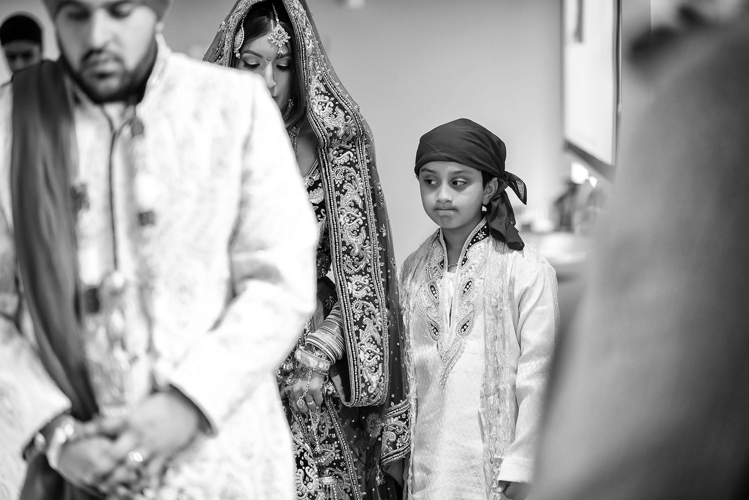 Black and white portrait of traditional Sikh wedding ceremony participants.
