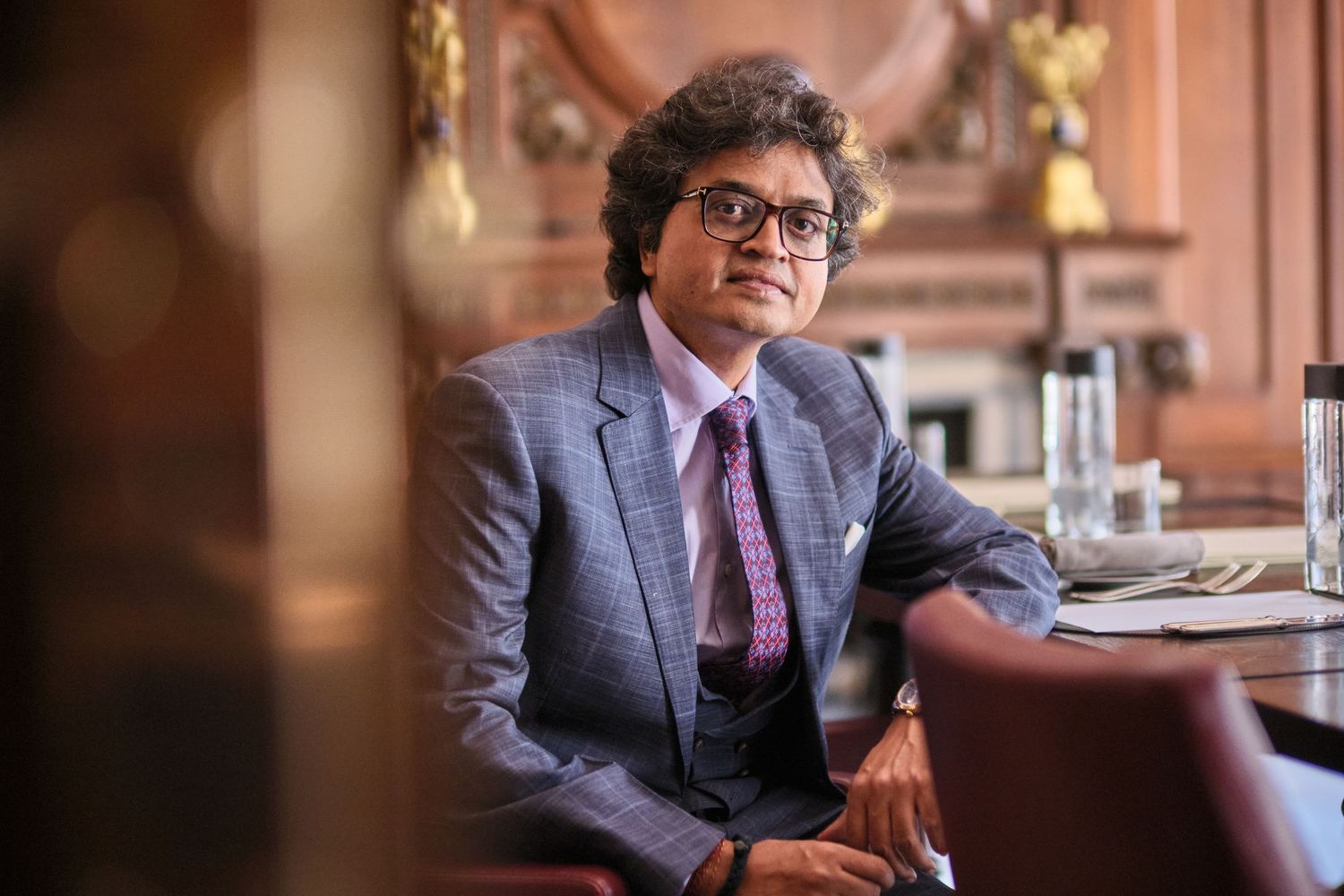 Professional business portraits in elegant office setting with warm lighting.