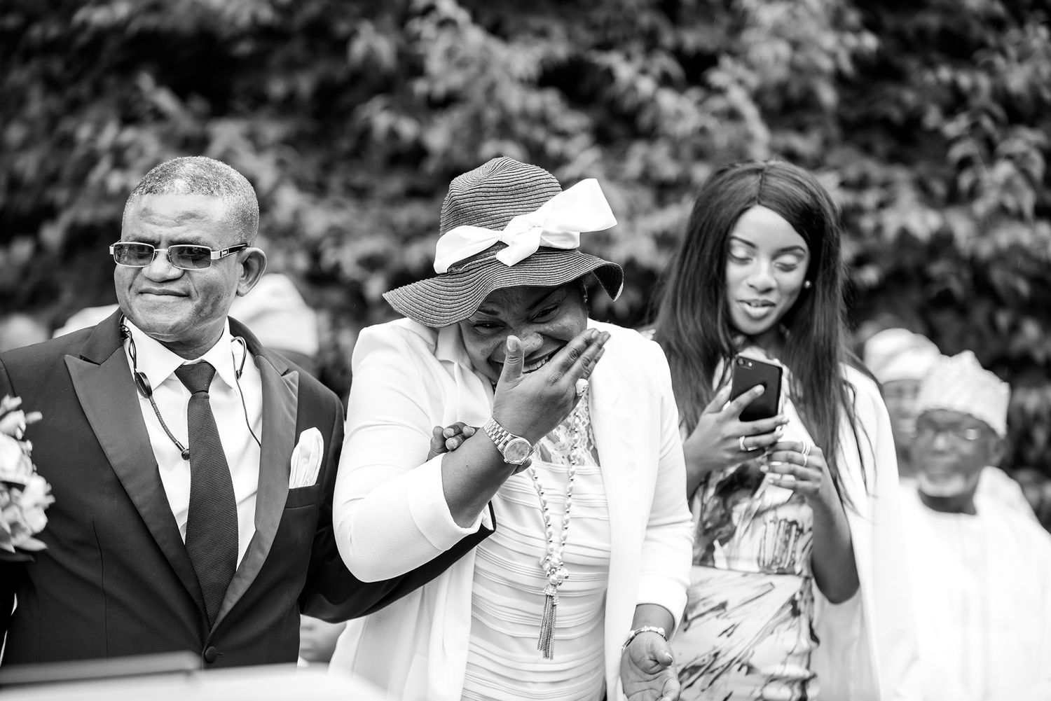 Wedding party members share joyful moments during outdoor celebration.