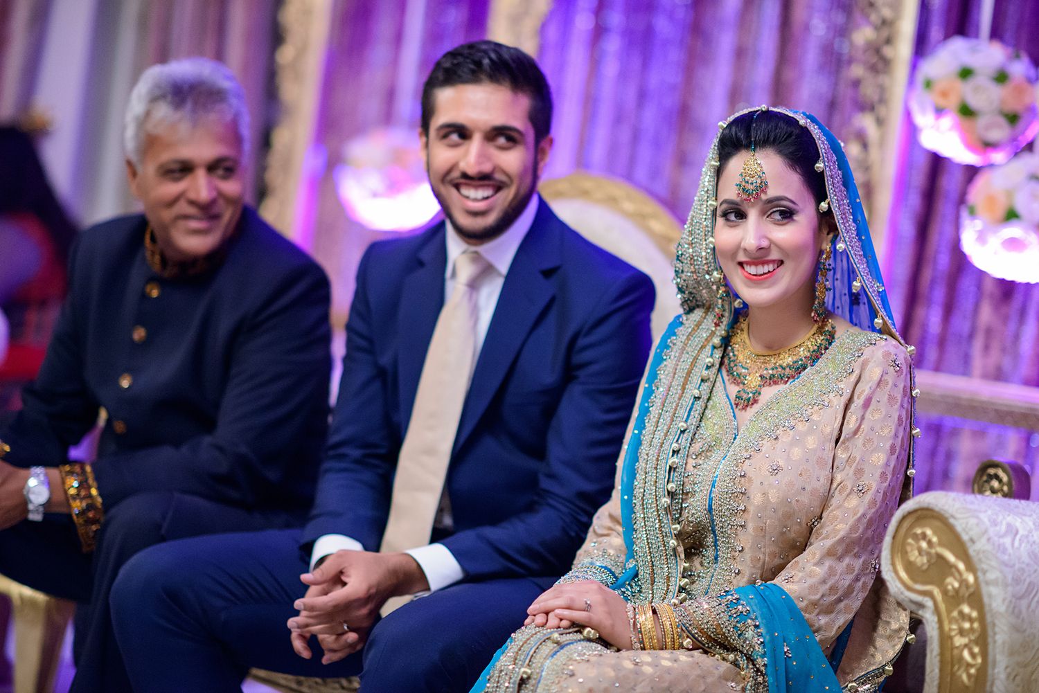 Wedding celebration with purple ambient lighting and elegant traditional decor.