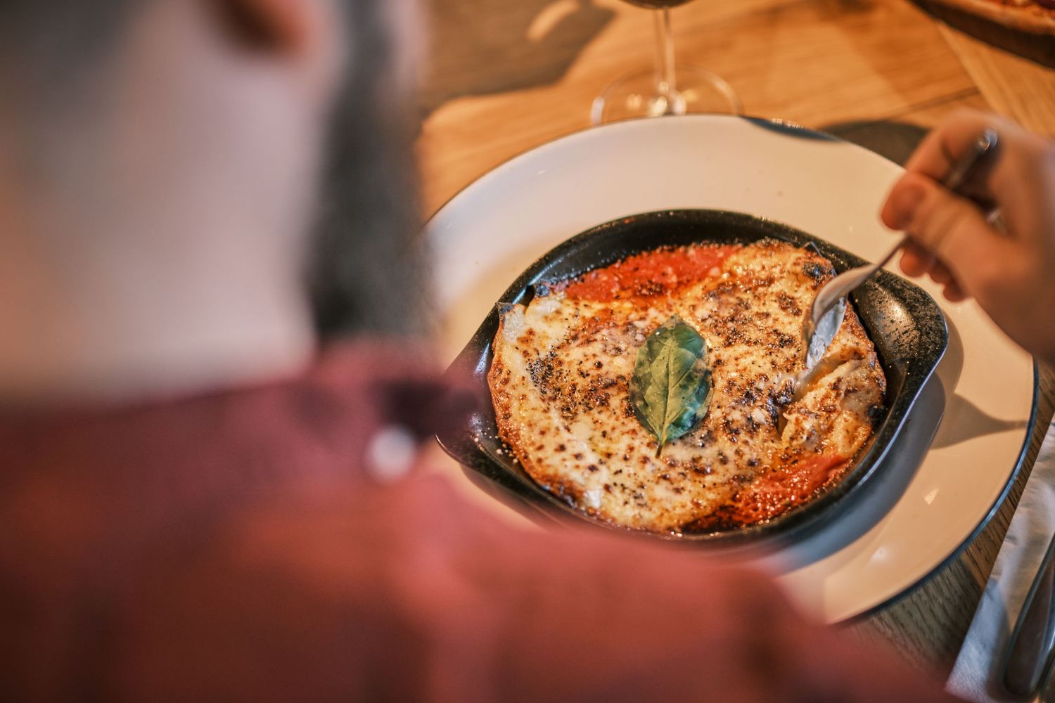 Delicious pizza dishes being served in a cozy restaurant setting with warm lighting and rustic ambiance.