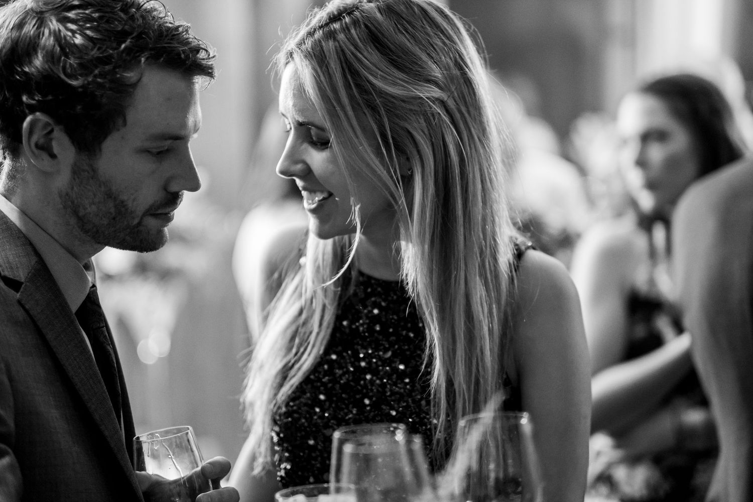 Intimate black and white candid moments during an elegant wedding reception.