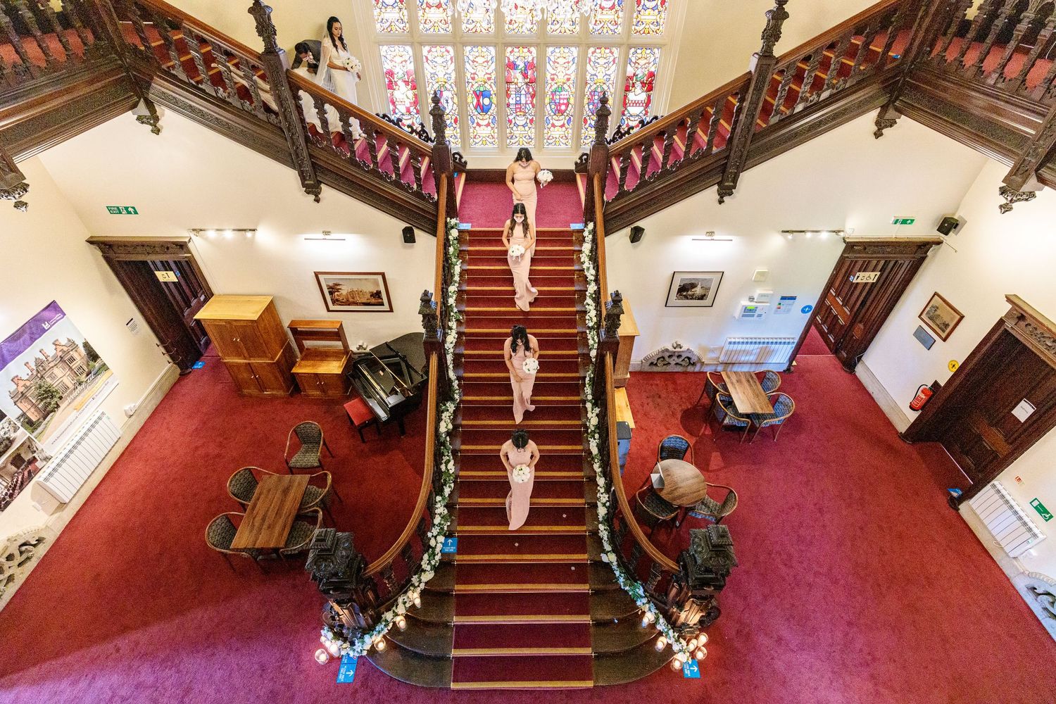 Aerial view of a church interior with red carpeted stairs and wooden pews.