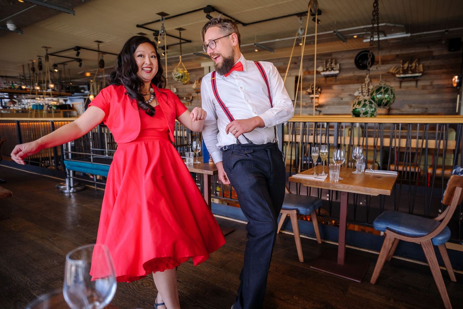 Couple and their black dog enjoying candid moments in a rustic indoor setting with wooden furniture.