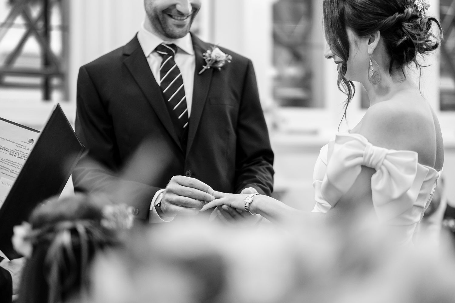 Black and white candid shots of wedding guests smiling and interacting at a reception.