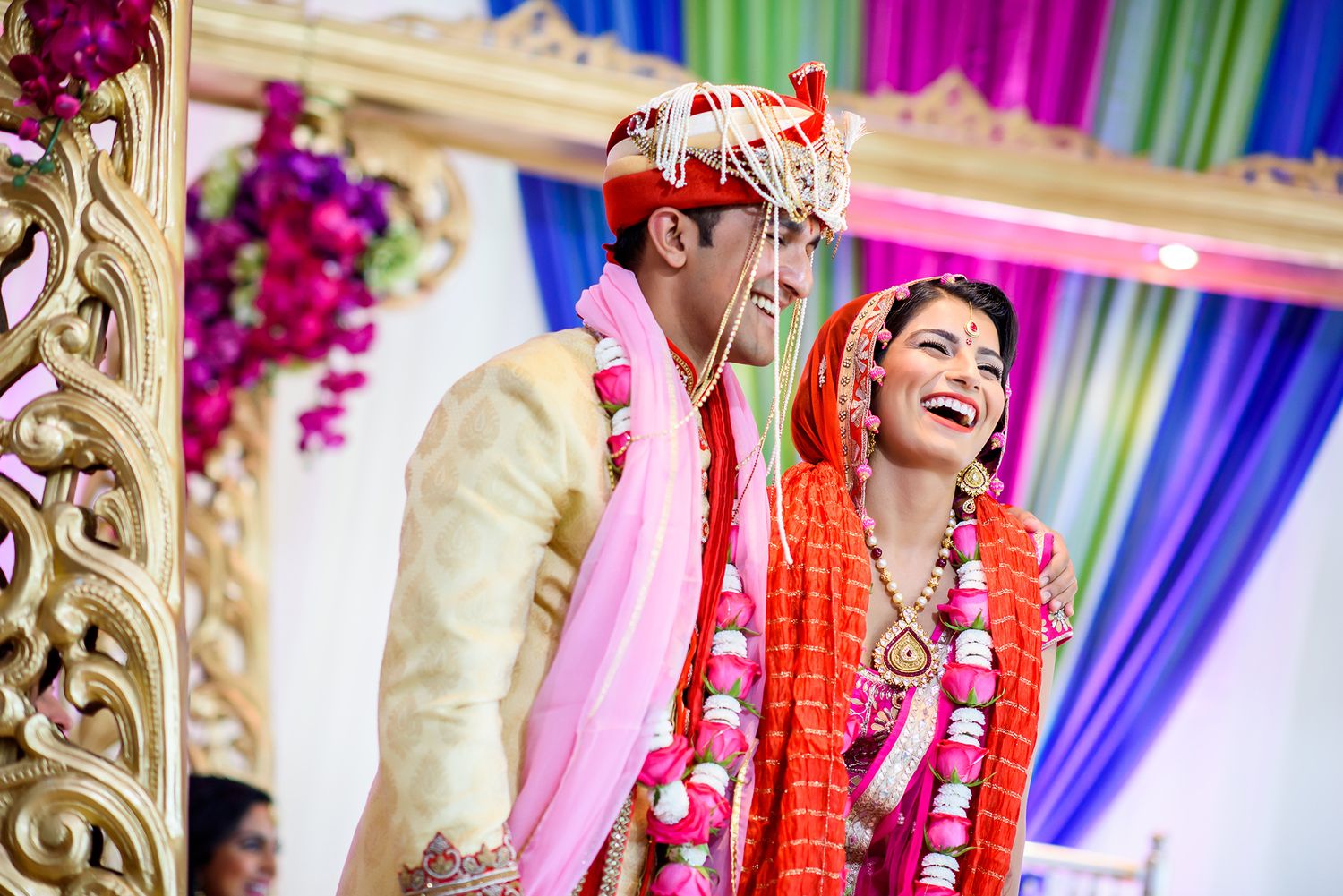 Colorful decorations and floral arrangements adorn an elegant Indian wedding ceremony venue.