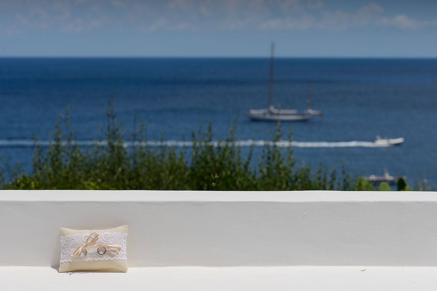 Tropical beachfront setting with bright blue ocean and speedboat in the distance.