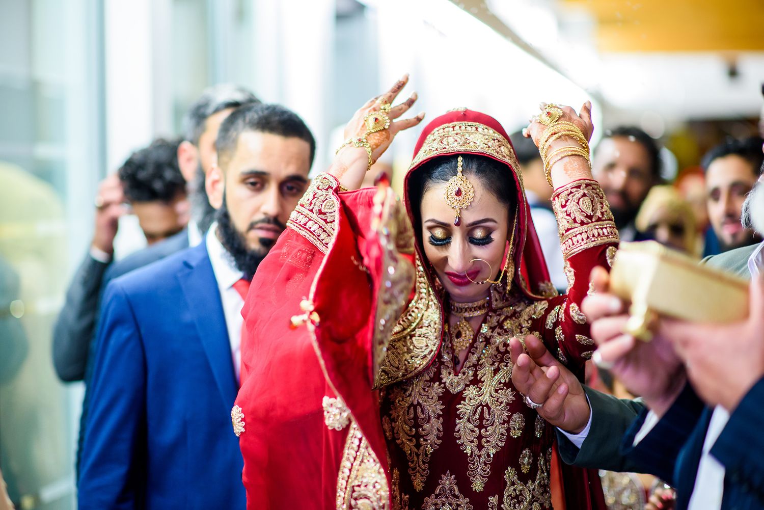 Wedding celebration showing guests in formal attire and traditional red garments.