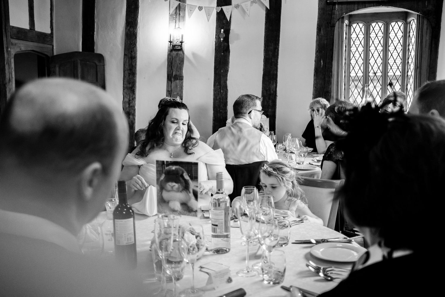 Elegant wedding reception in a historic venue with Tudor-style windows and formal table settings.
