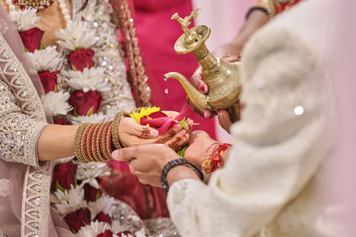 Traditional Indian wedding ceremony with ornate decorations and floral arrangements in red and gold colors.