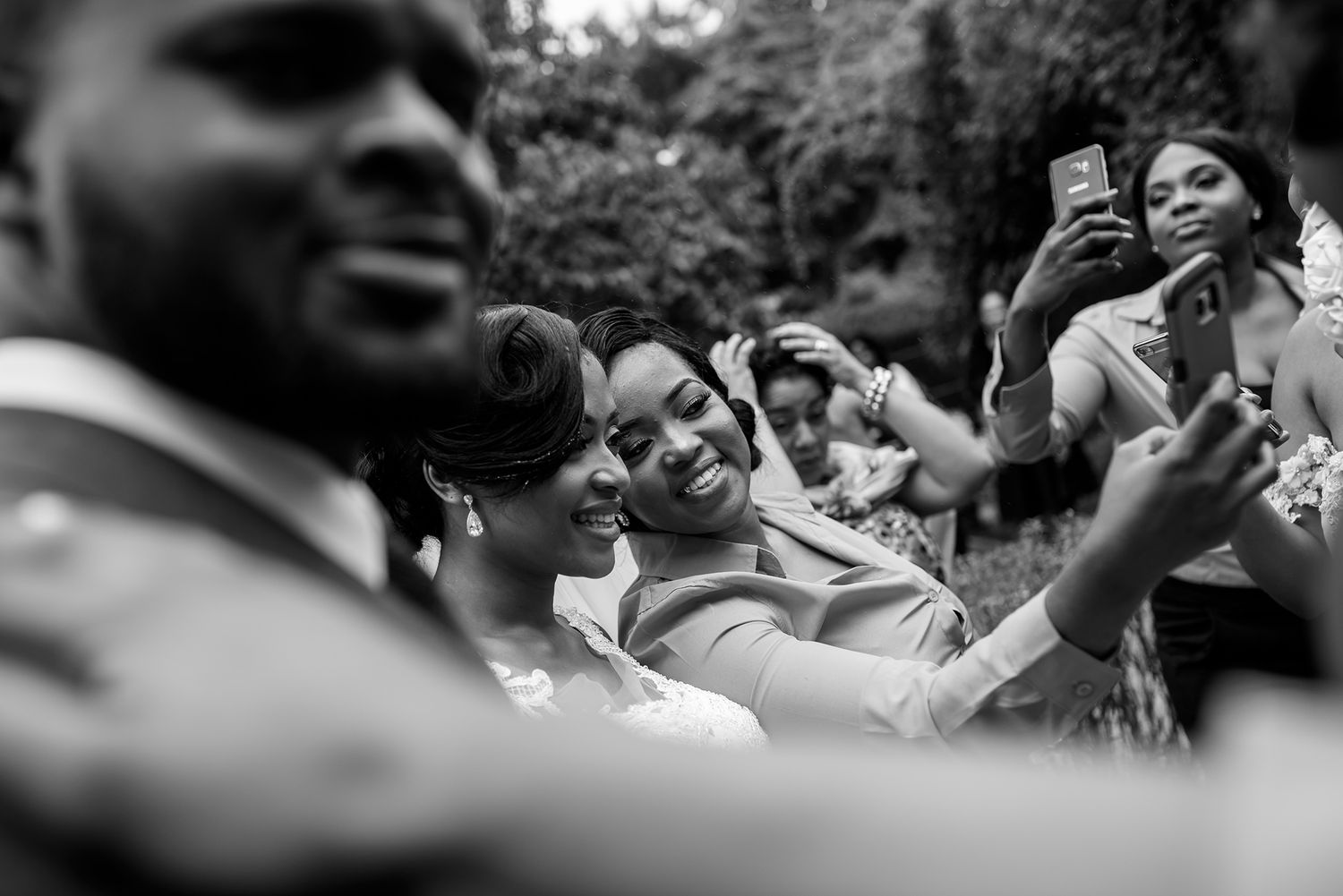 Candid black and white shots of wedding guests reacting with joy during the celebration.