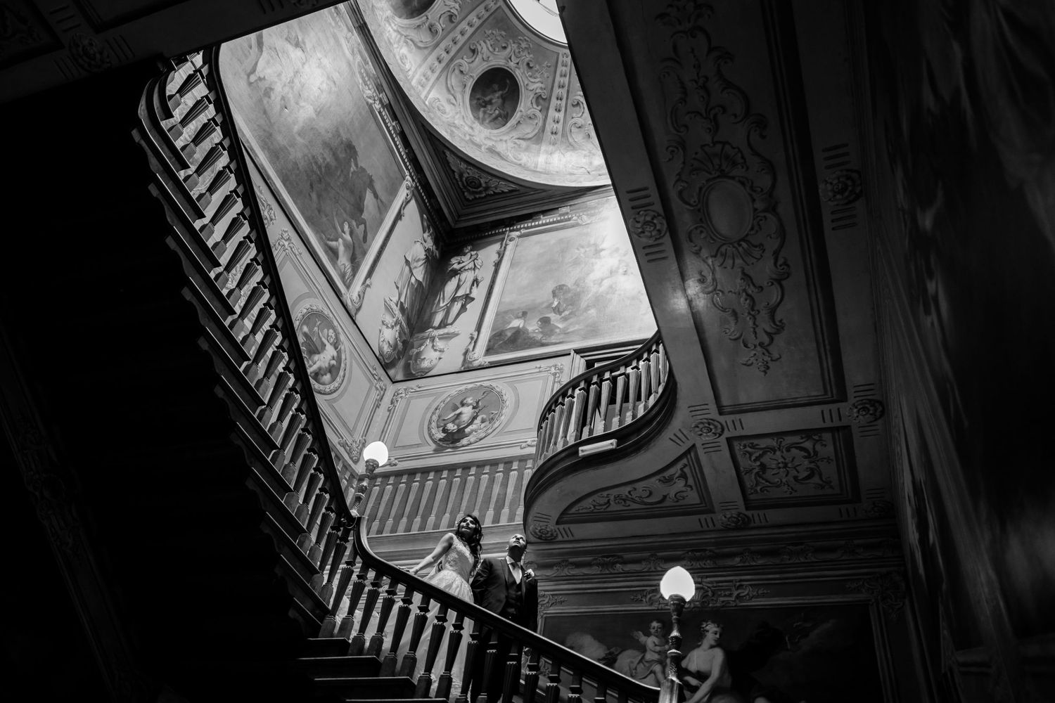 Black and white view of an elegant curved staircase in a historic building.