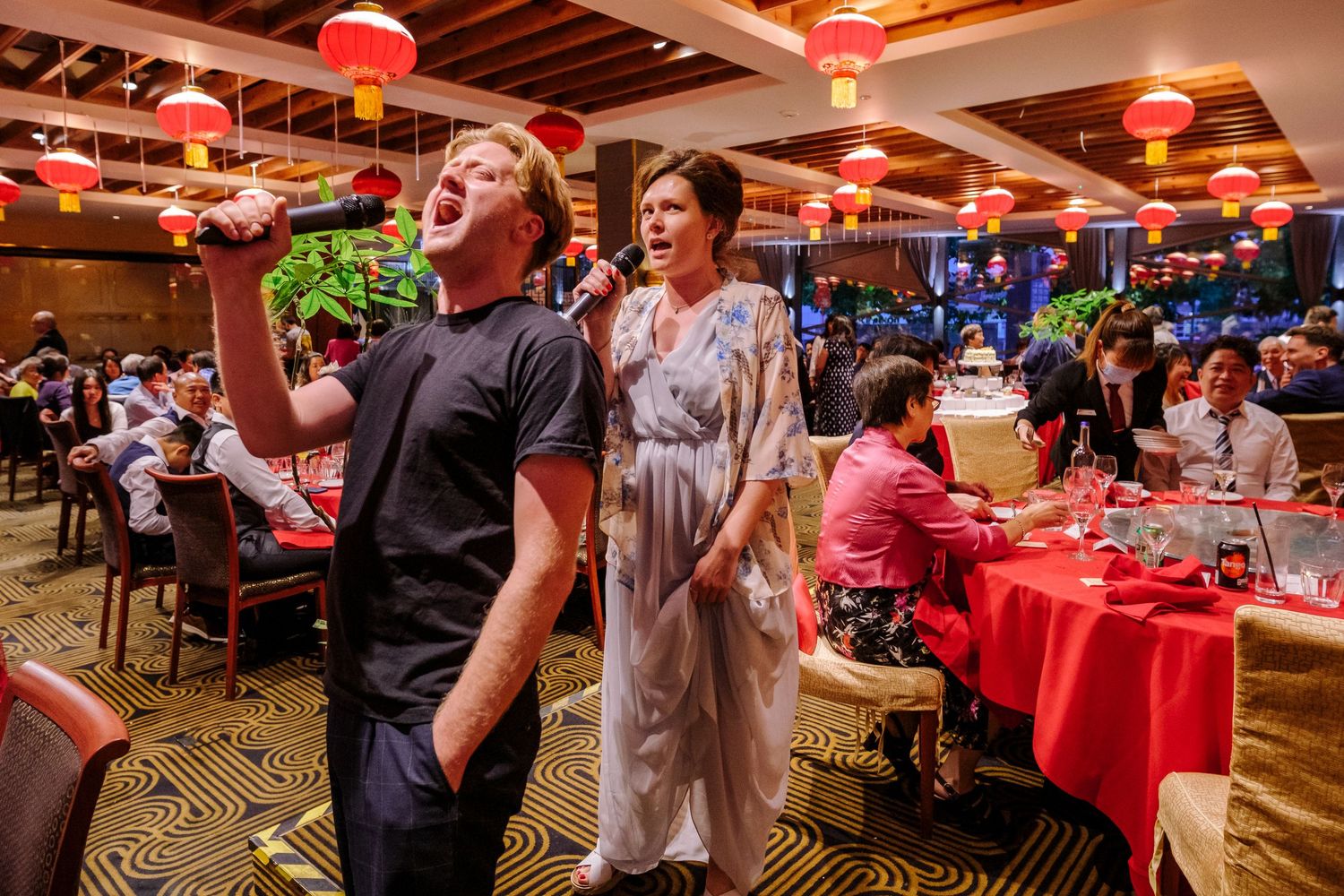 Panoramic view of a Chinese restaurant interior with red tablecloths and traditional decorations.