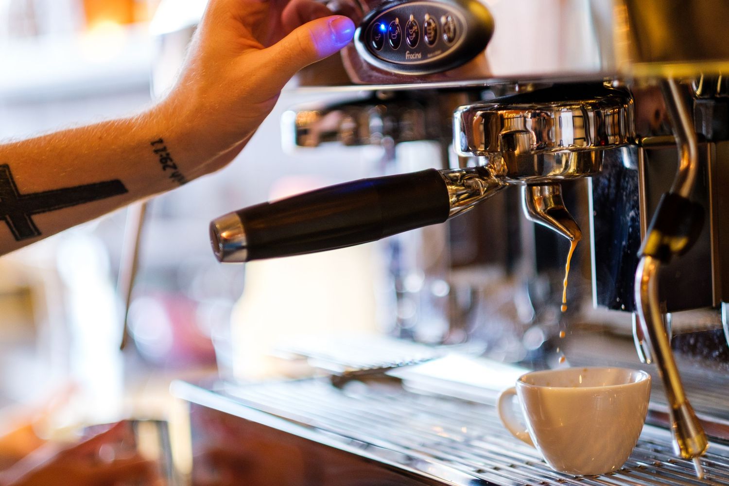 Close-up of professional espresso machine brewing coffee in a cafe setting.