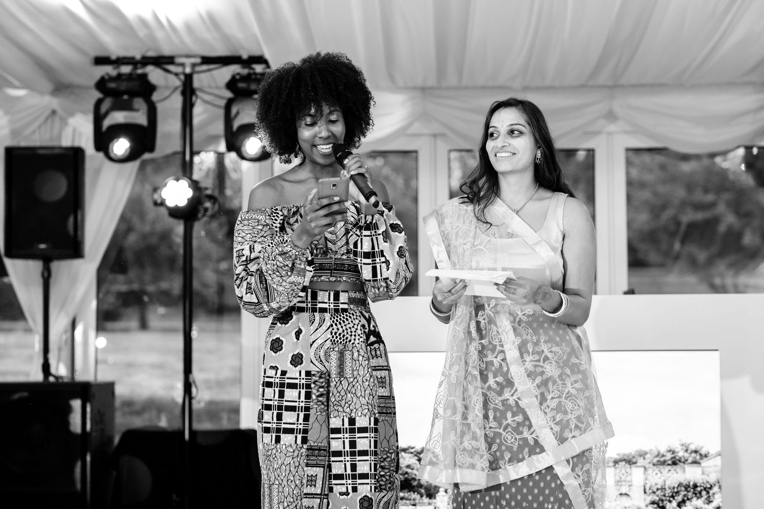 Black and white photo of wedding guests dancing and celebrating at reception party.