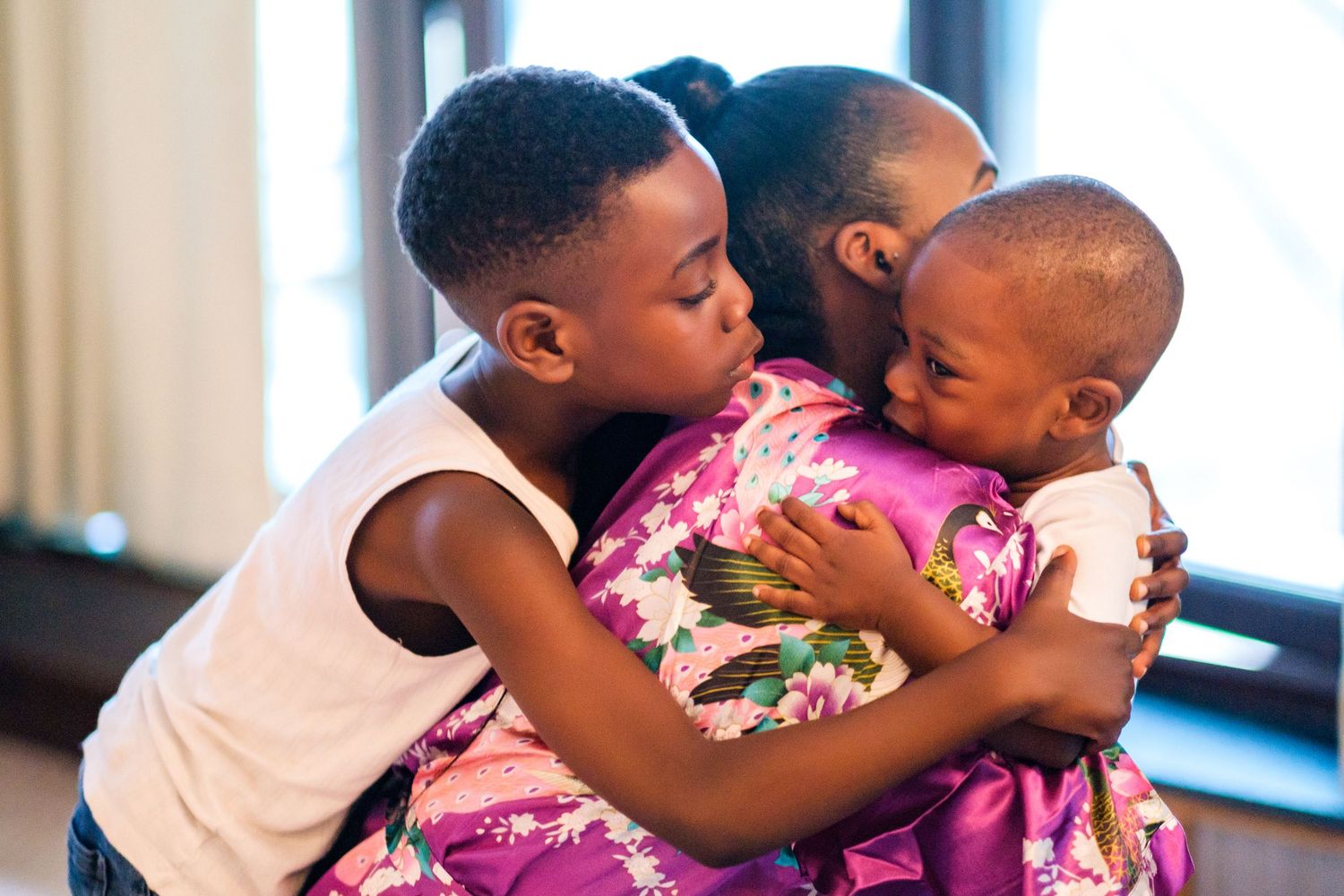 Wedding party members share emotional embraces and hugs during a touching moment at the celebration.