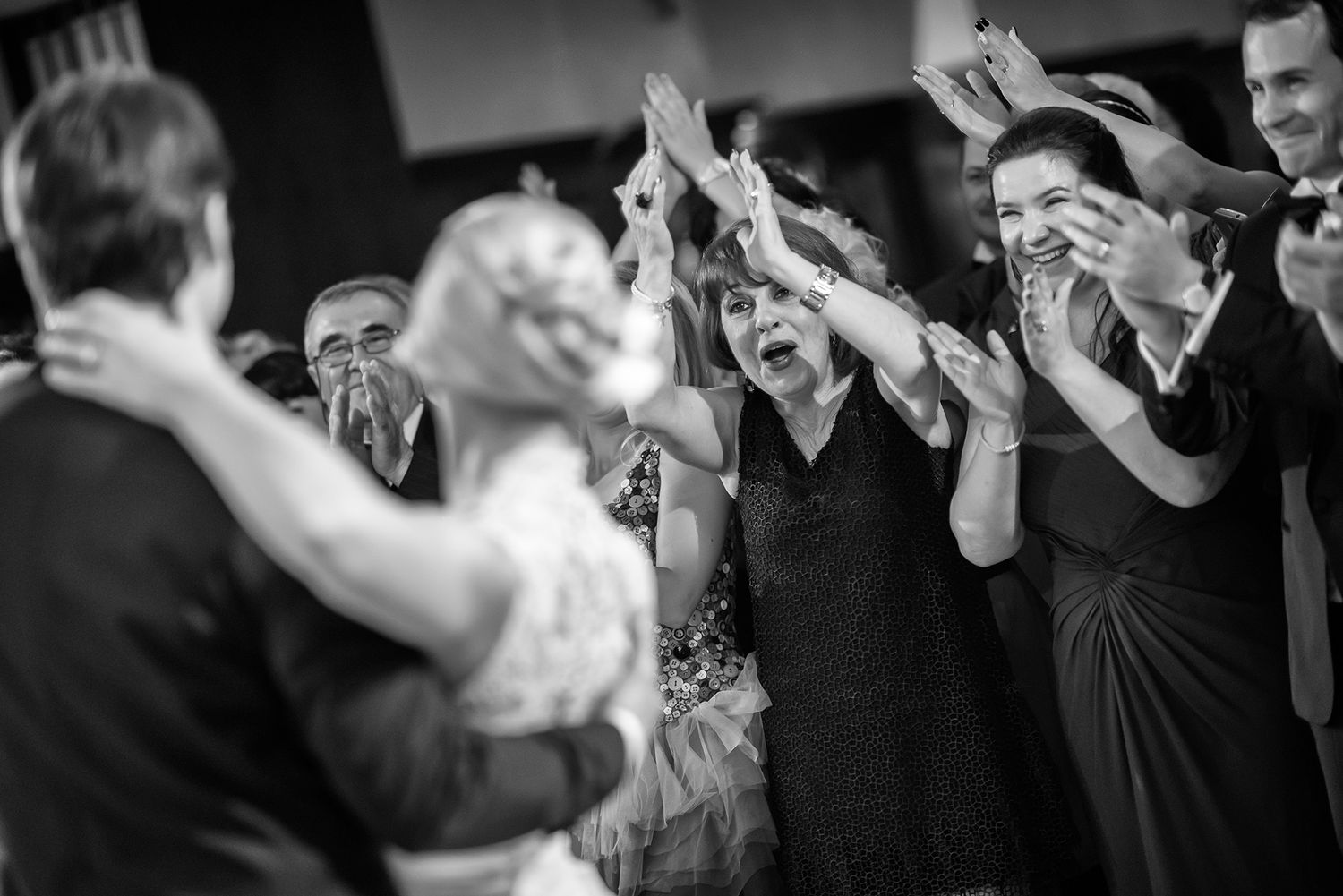 Black and white photo of wedding guests dancing and celebrating.