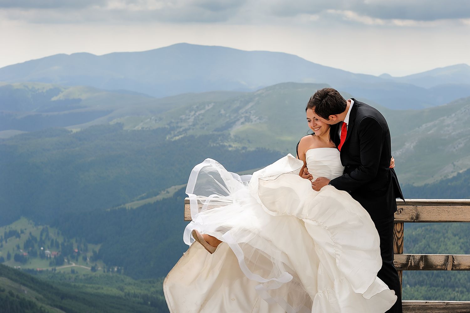 Scenic mountain landscape wedding photos with flowing white dress caught in the breeze.
