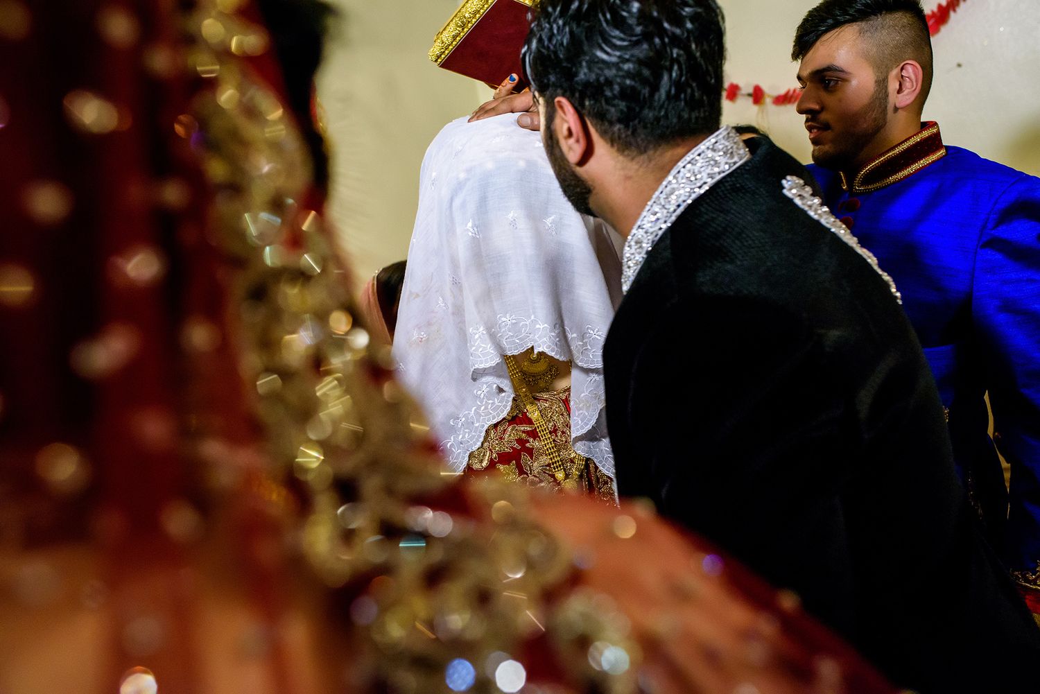 Wedding guests mingle during reception with warm ambient lighting.